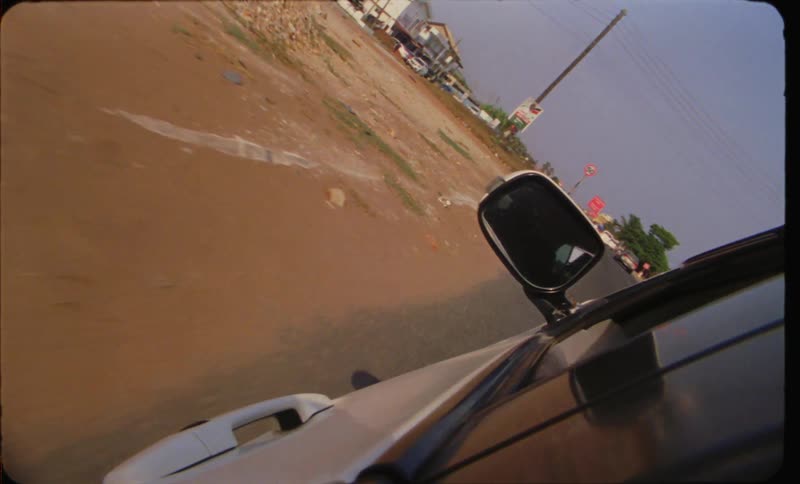 A person is driving a car while the sun is setting