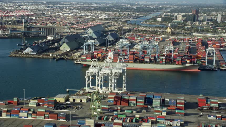 Aerial view of cranes loading containers onto a cargo ship at the bustling Port of Long Beach California
