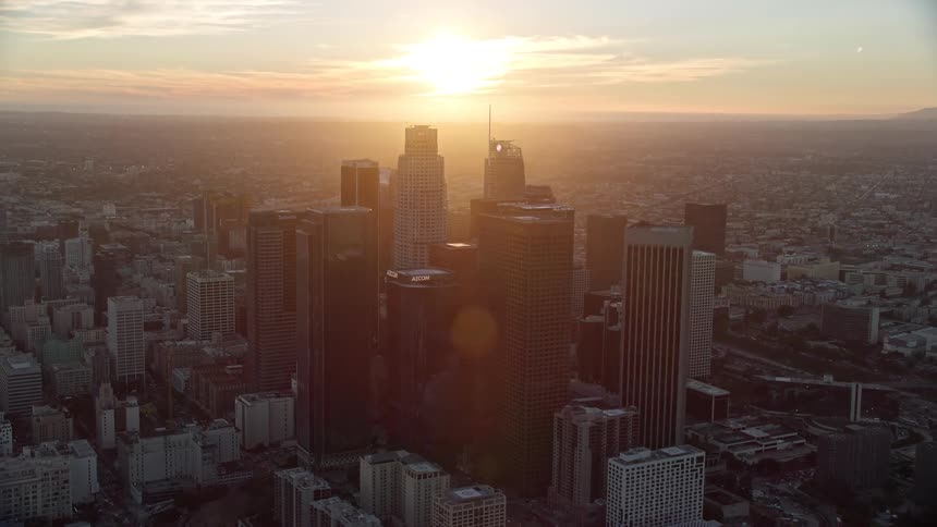 A stunning aerial view of the tall towers of downtown Los Angeles at sunset captured during the summer season