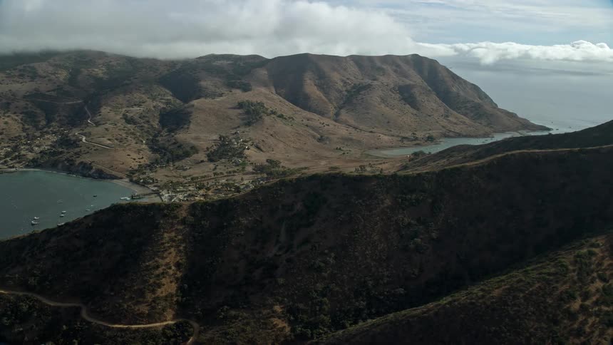 Aerial footage of Two Harbors island community in Santa Catalina Island California showing a reverse view of the residential and industrial areas from above