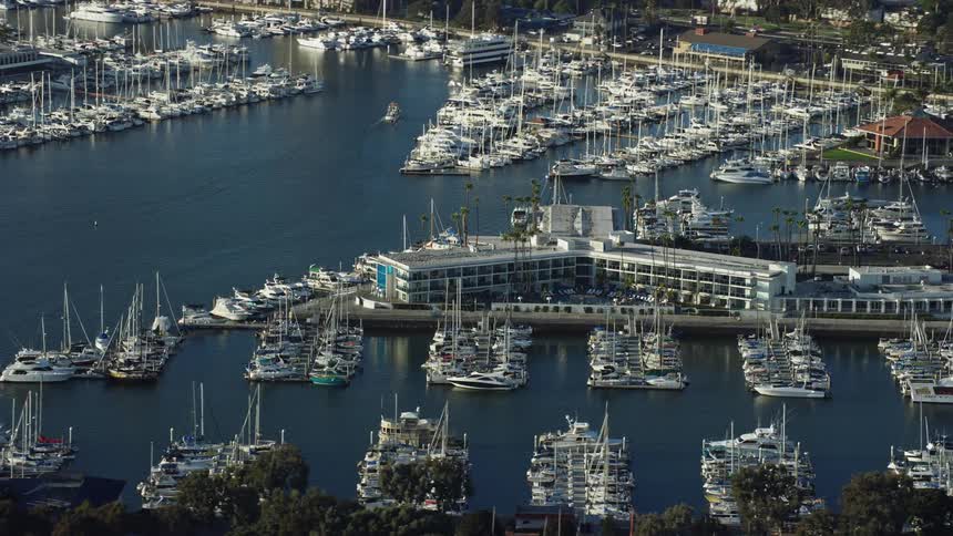Aerial footage of Marina Del Rey Hotel and boats docking in the marina in sunny California