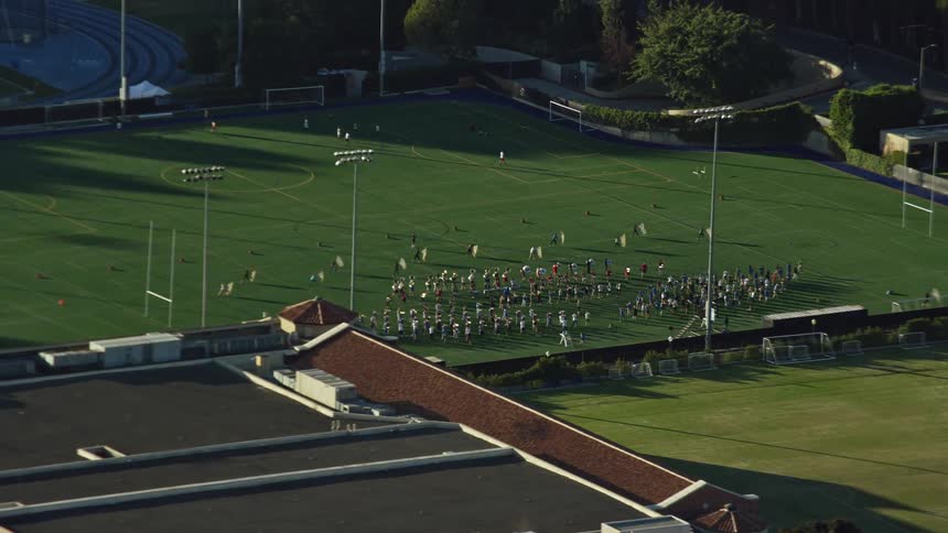 Aerial view of the college band practicing on the Intramural Field in Los Angeles California during the daytime with beautiful sunshine and blue skies