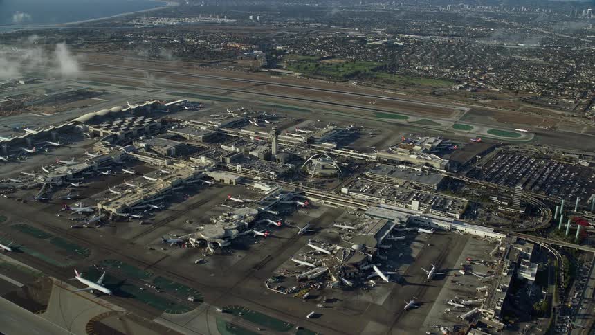 Aerial view of planes taxiing on runways of LAX airport California on partly cloudy day