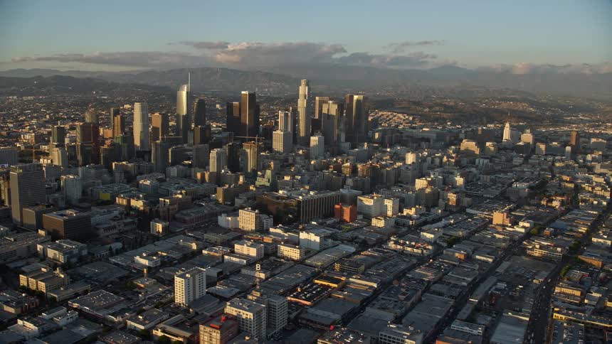 Towering skyscrapers adorn the Southern California skyline in a aerial clip of Downtown Los Angeles during a partly cloudy day