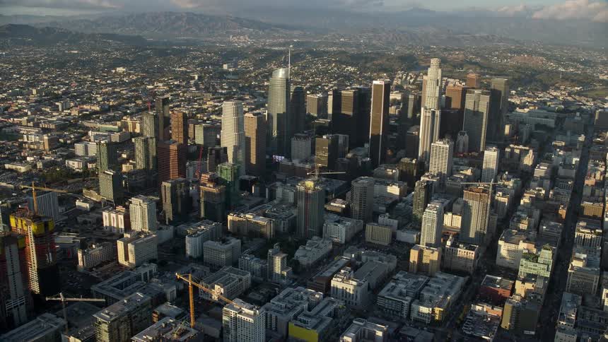 Fly over the high rise towers and heavy traffic of downtown Los Angeles approaching Aon Center on Highway 110 during rush hour in Southern California