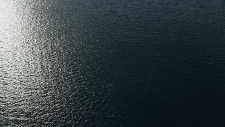 Aerial footage of the Pacific Ocean off the coast of Southern California during daytime with partly cloudy skies