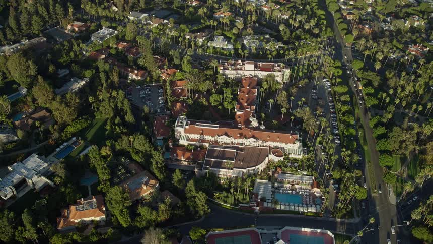 A stunning aerial footage showcasing the reverse view of the Beverly Hills Hotel and beautiful surrounding and sunny Beverly Hills California