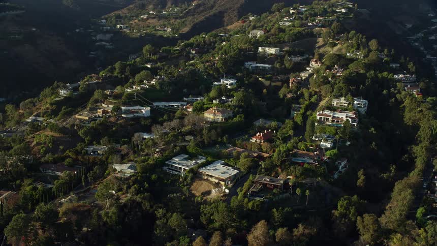 A stunning aerial view of luxurious hillside mansions in Beverly Hills California captured during a sunny day in spring or summer