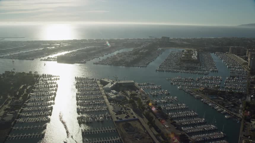 This is an aerial view of the marinas and waterfront apartment buildings in Marina Del Rey California during the day featuring boats docks and residential buildings