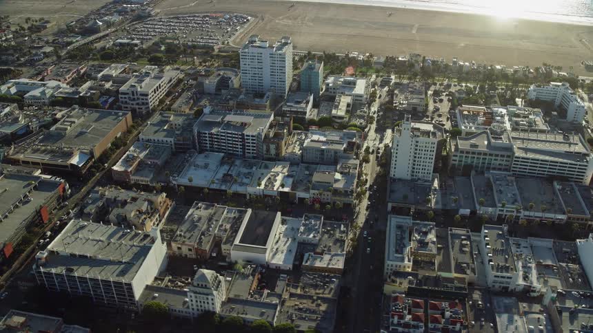 Aerial view of 3rd Street Promenade shops and office buildings with a glimpse of the ocean in Santa Monica during a sunny day in California