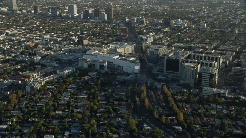 Aerial footage over Beverly Center mall and Cedars-Sinai Medical Center in Beverly Hills CA on a sunny day shot from a Shotover F1 on Epic Helium camera showing the retail and medical centers in the West Coast during summer