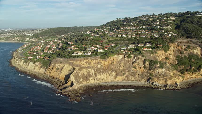 Aerial footage of luxurious mansions overlooking the beach at Flat Rock Point in Palos Verdes Estates California captured from a angle