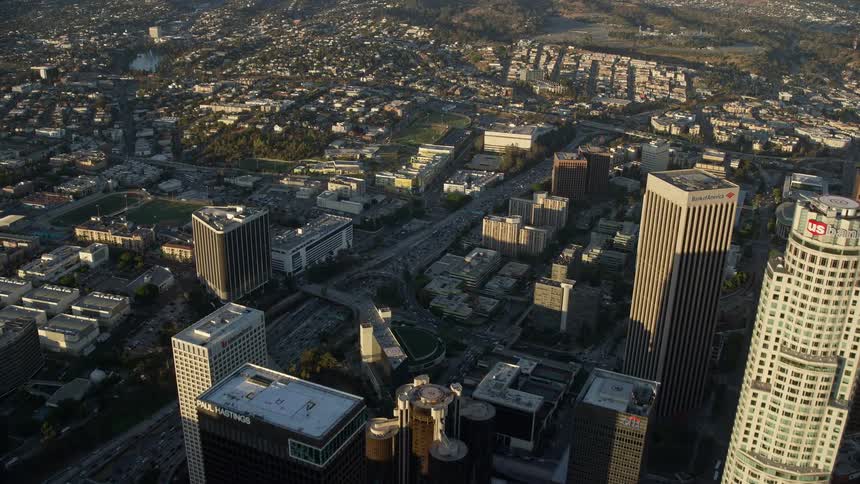 Flying over Aon Center and heavy traffic on Hwy 110 in downtown LA on a sunny day