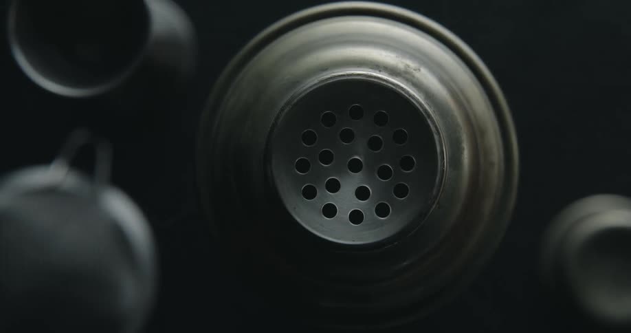 A top shot of a cocktail shaker and other mixologist tools