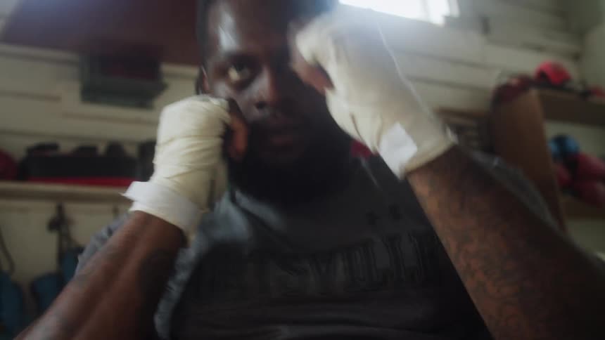 A boxer is doing a combination of sit ups and punches in a gym