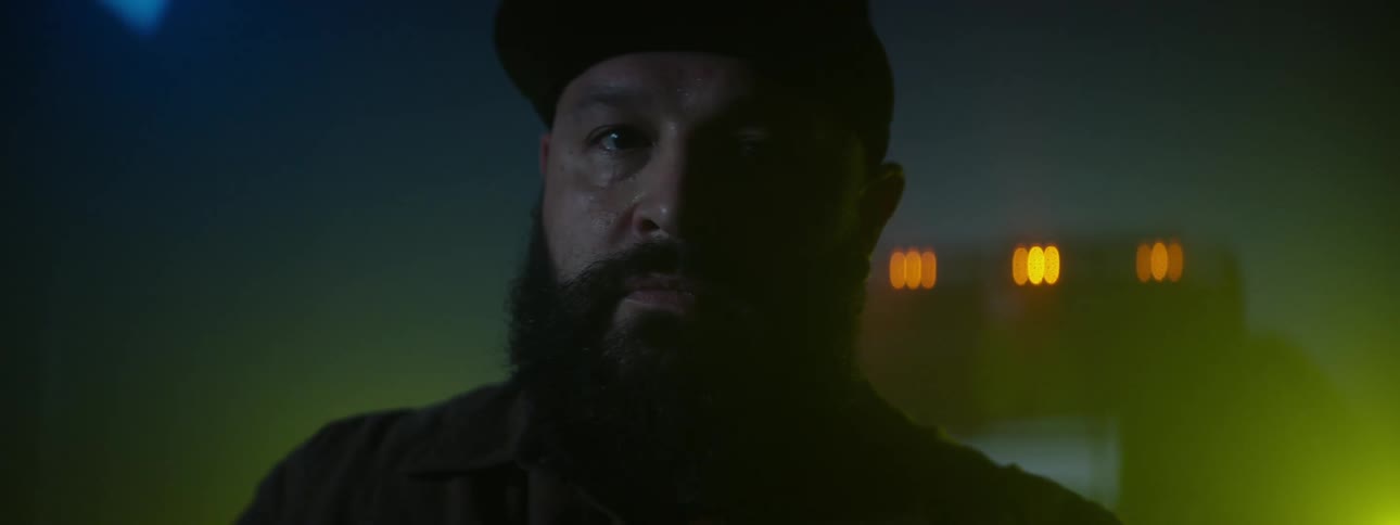 A man is standing in front of his truck at night