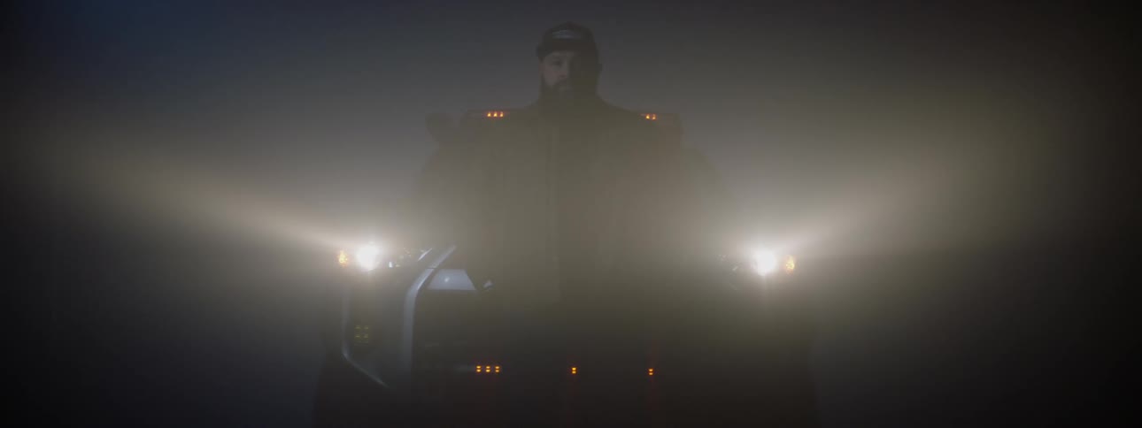 A man poses on the hood of his car