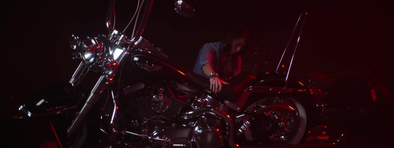 A woman stands up and walks away from the motorcycle