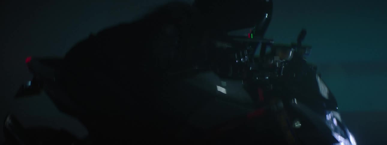 A person riding a motorcycle outdoors at night