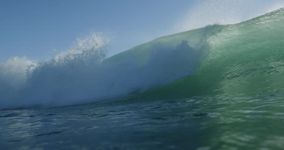 A large wave rises and falls in the ocean