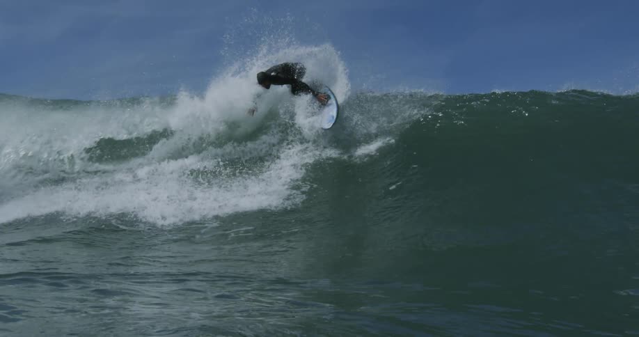 Man in wetsuit surfs waves off the coast
