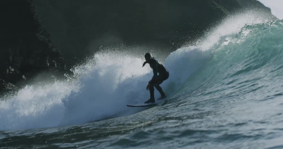A surfer rides a tall wave in the ocean