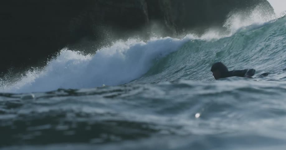 A man taking off on a wave