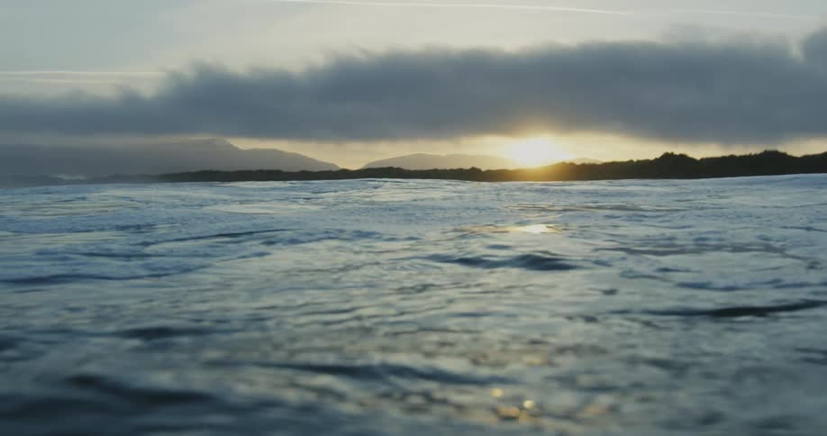 Waves ripple in the ocean at dusk