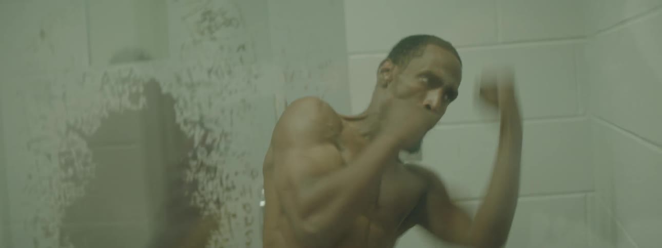 A man is shadow boxing in a prison cell