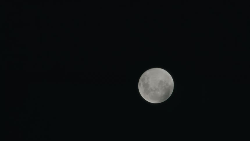 Clouds move over a full moon