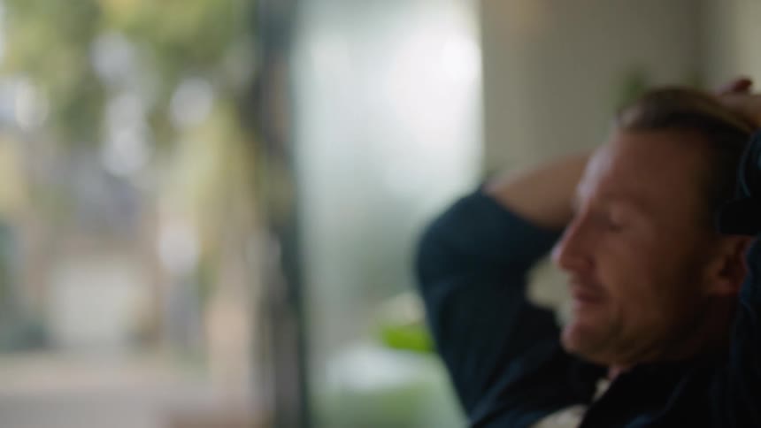 A close up of a mans face very disgruntled and stressed then throwing papers up in the air and putting his hands on his head