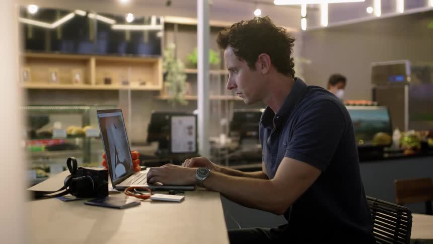 A man works on his laptop in a restaurant