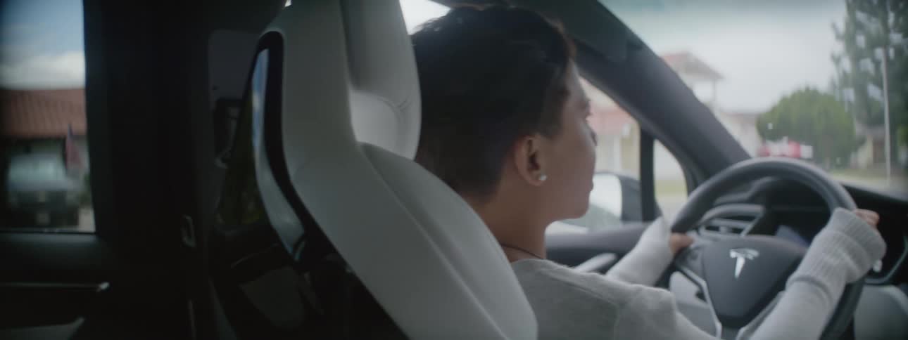 A woman and her daughter having a conversation while driving through a neighborhood
