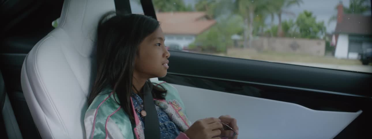 Young kid sitting in the car in the middle of the day