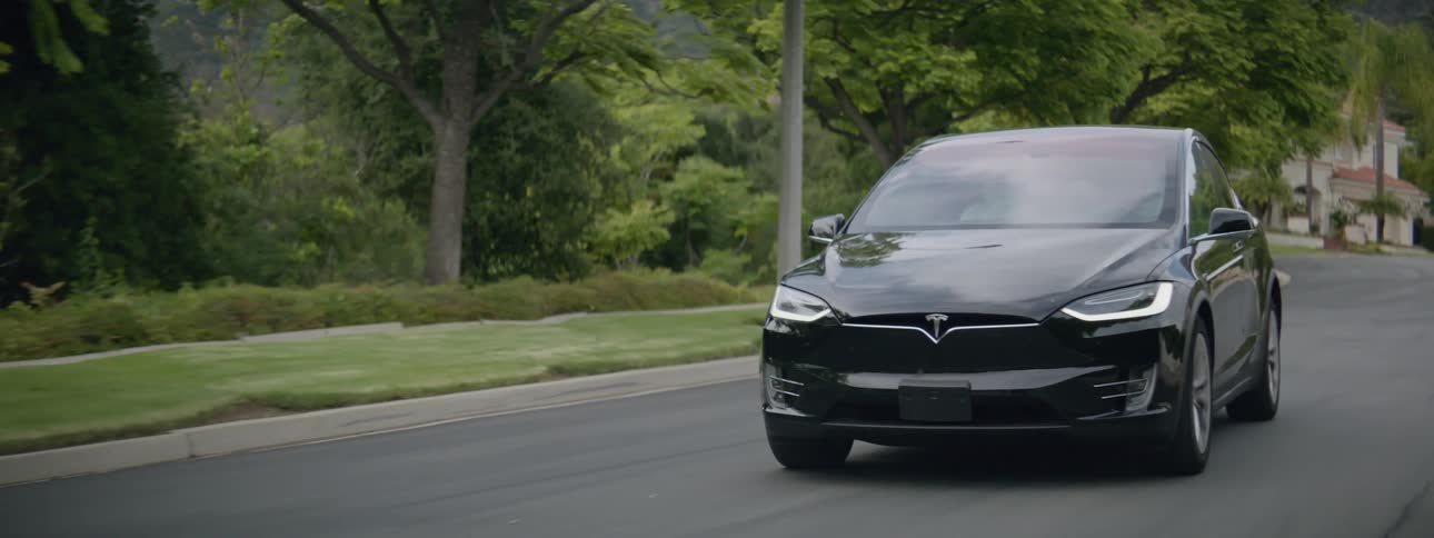 The car is driving down the road