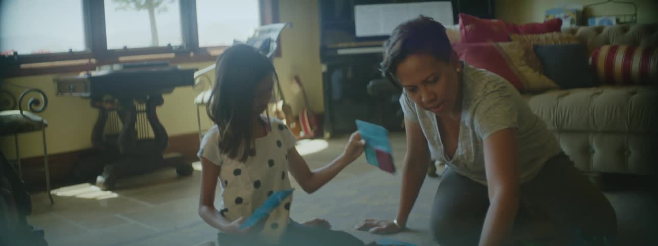 A mother sitting on the floor with her daughter putting puzzle pieces together