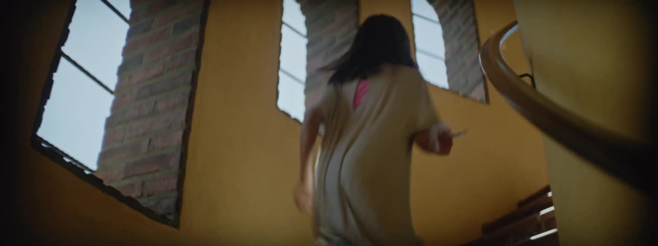 A yellow painted stairwell as a young girl runs up the stairs
