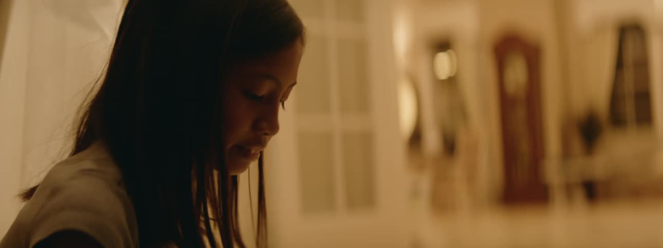 Young kid is sitting down inside of her home in the day time