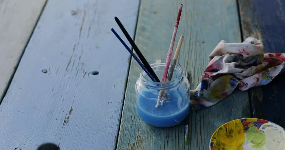 There is paint on a bench outside in the day time