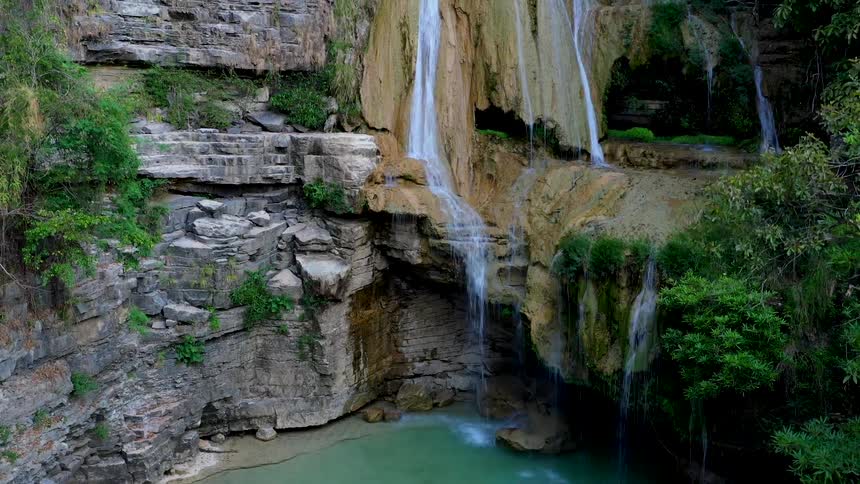 A waterfall with trees and a pound