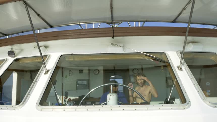 A man is steering a yacht
