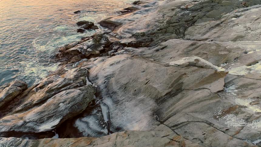 Aerial view of the coastline near rock slopes next to the ocean