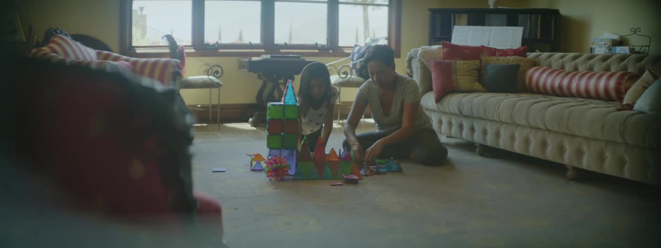Mother and daughters are sitting on the floor in the day time
