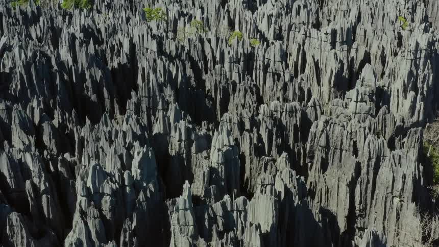 An aerial of large rock formations and trees growing between them