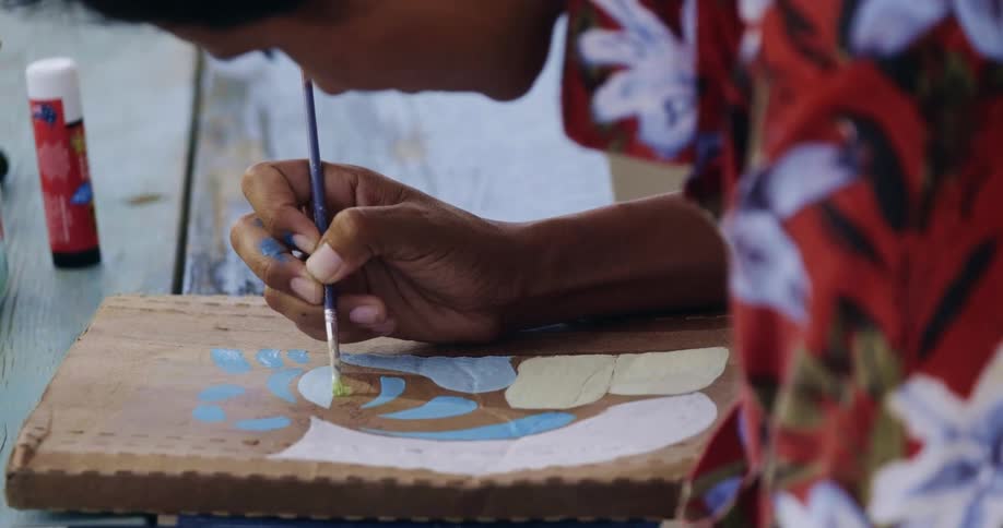 A person painting on a box