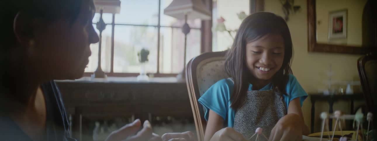 Mother and daughter are sitting at the table and laughing