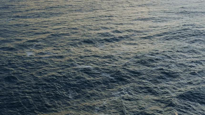 Aerial view of body of ocean water at dusk