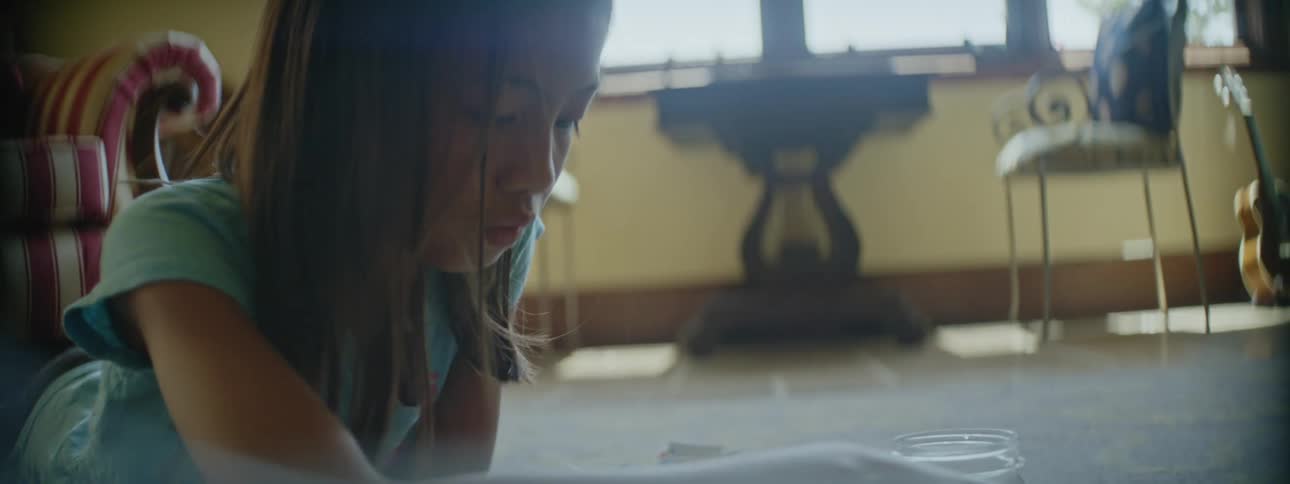 Young kid is laying on the floor of her bedroom