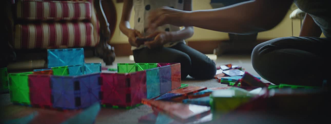A mother and daughter play with toys