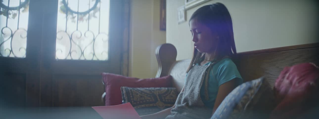 A child is writing on the couch